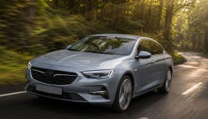 Opel Insignia en train de rouler sur une belle route traversant une forêt