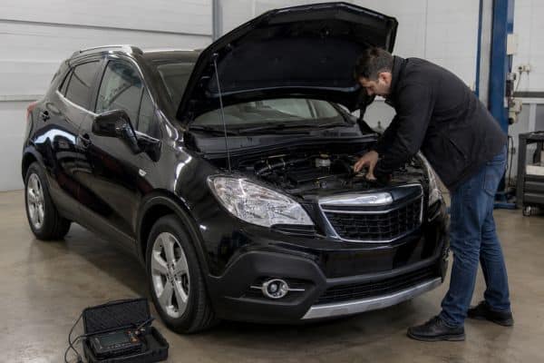 Opel Mokka 1.6 CDTI 136 arrêté dans un garage propre, capot ouvert, pendant une inspection avant achat
